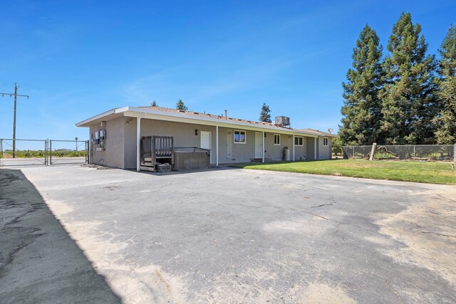 570 S Lassen Ave, Kerman, CA 93630 - view of front facade with a jacuzzi, a gate, and stucco siding