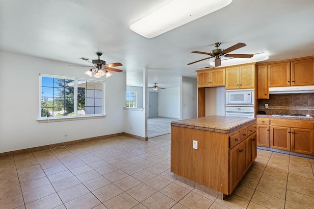 570 S Lassen Ave, Kerman, CA 93630 - kitchen with ceiling fan, white appliances, light tile patterned floors, backsplash, and tile countertops