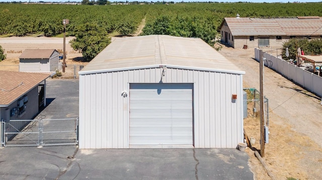 570 S Lassen Ave, Kerman, CA 93630 - detached garage featuring agricultural area, a gate, and a view of countryside