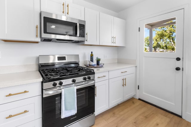 3486 E Lamona Ave, Fresno, CA 93703 - kitchen with stainless steel appliances, light countertops, light wood-style floors, and white cabinets