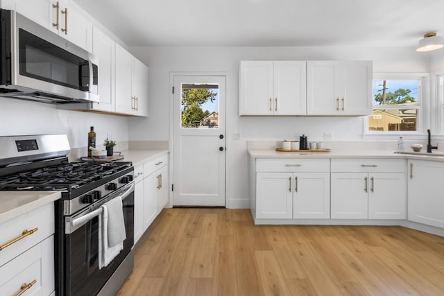 3486 E Lamona Ave, Fresno, CA 93703 - kitchen with appliances with stainless steel finishes, healthy amount of natural light, light countertops, and light wood-style floors