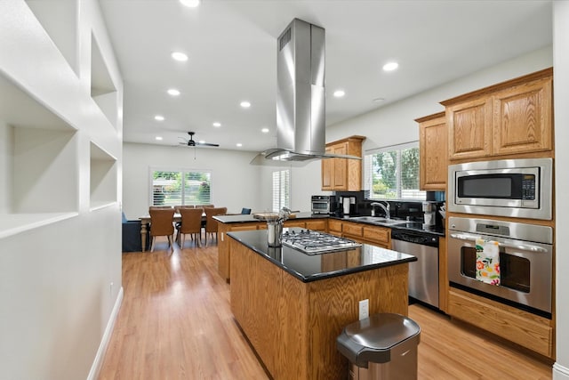 135 N Park Dr, Madera, CA 93637 - kitchen with appliances with stainless steel finishes, island range hood, healthy amount of natural light, light wood-style flooring, and recessed lighting