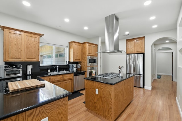 135 N Park Dr, Madera, CA 93637 - kitchen featuring stainless steel appliances, island range hood, dark countertops, a kitchen island, and arched walkways