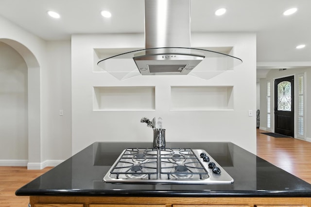 135 N Park Dr, Madera, CA 93637 - kitchen featuring wood finished floors, dark countertops, stainless steel gas cooktop, arched walkways, and recessed lighting