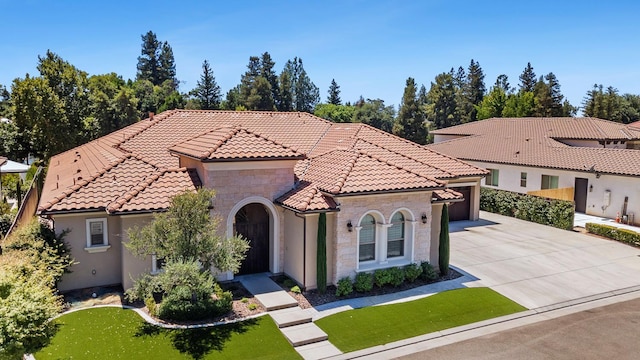2706 Trenton Ave, Clovis, CA 93619 - mediterranean / spanish-style home with concrete driveway, a tiled roof, stone siding, a garage, and a front lawn