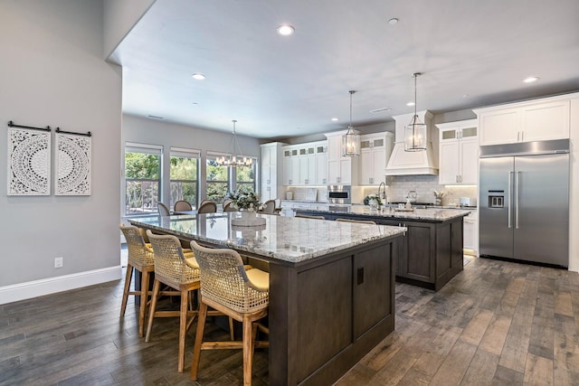 2706 Trenton Ave, Clovis, CA 93619 - kitchen with built in refrigerator, an island with sink, dark wood finished floors, recessed lighting, and backsplash