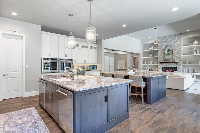 2706 Trenton Ave, Clovis, CA 93619 - kitchen with a kitchen island with sink, oven, dark wood finished floors, white cabinetry, and recessed lighting