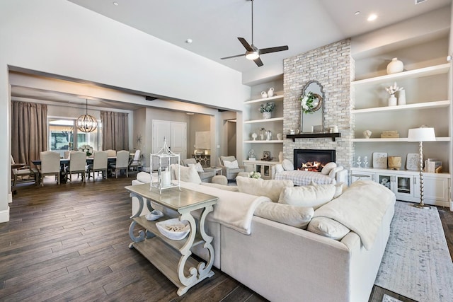 2706 Trenton Ave, Clovis, CA 93619 - living room featuring ceiling fan, dark wood finished floors, built in features, a fireplace, and a chandelier