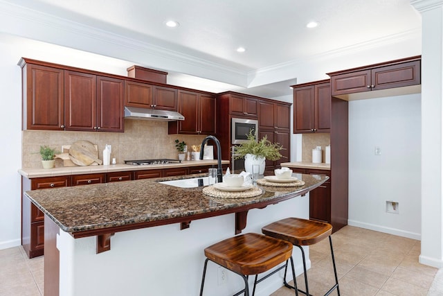 4160 N Creekbend, Clovis, CA 93619 - kitchen featuring under cabinet range hood, appliances with stainless steel finishes, tasteful backsplash, a center island with sink, and recessed lighting