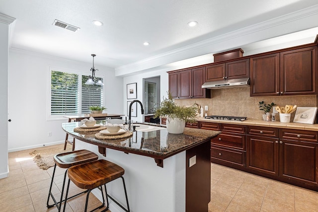 4160 N Creekbend, Clovis, CA 93619 - kitchen with under cabinet range hood, light tile patterned floors, a breakfast bar, tasteful backsplash, and a chandelier