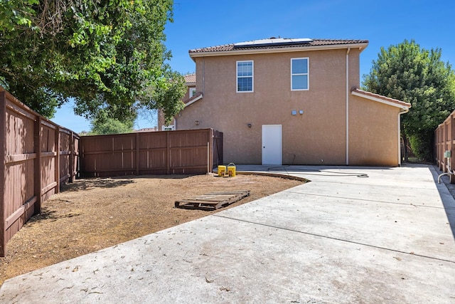 4160 N Creekbend, Clovis, CA 93619 - back of house featuring a fenced backyard, roof mounted solar panels, a patio, and stucco siding