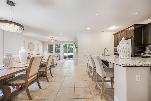 1728 E Green Sage Ave, Fresno, CA 93730 - kitchen featuring recessed lighting, light tile patterned floors, light stone counters, a breakfast bar area, and fridge