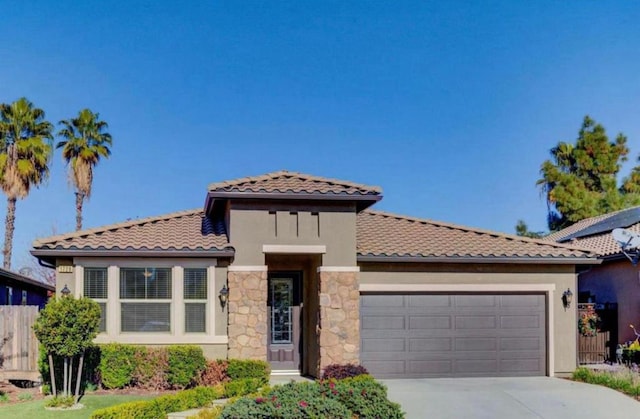 1728 E Green Sage Ave, Fresno, CA 93730 - mediterranean / spanish-style house with an attached garage, driveway, a tile roof, and stucco siding