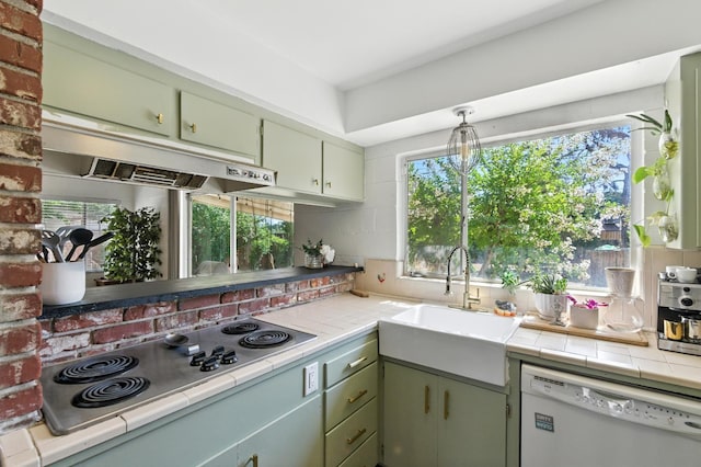 4678 N Thorne Ave, Fresno, CA 93704 - kitchen with white dishwasher, stainless steel electric cooktop, under cabinet range hood, tile countertops, and plenty of natural light