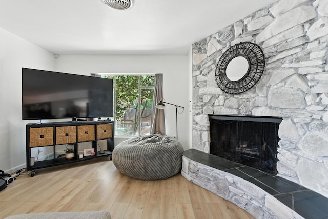 4678 N Thorne Ave, Fresno, CA 93704 - living area featuring wood finished floors and a stone fireplace