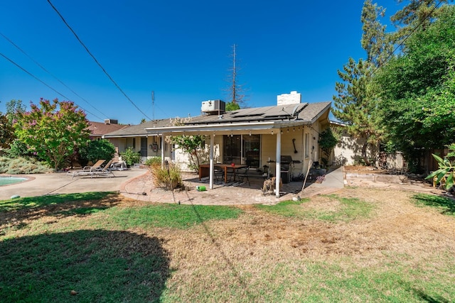 4678 N Thorne Ave, Fresno, CA 93704 - rear view of property featuring a patio area, solar panels, a fenced backyard, and a chimney