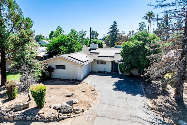 4678 N Thorne Ave, Fresno, CA 93704 - view of front facade with a shingled roof, roof mounted solar panels, brick siding, concrete driveway, and a chimney