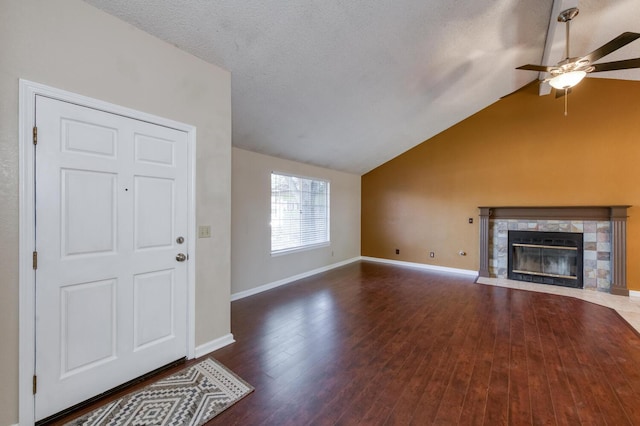 6283 N Gilroy Ave, Fresno, CA 93722 - unfurnished living room featuring ceiling fan, vaulted ceiling, a tiled fireplace, and wood finished floors