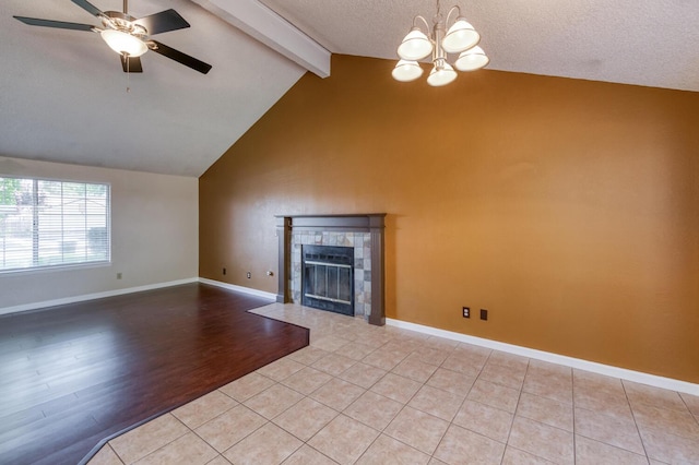 6283 N Gilroy Ave, Fresno, CA 93722 - unfurnished living room with a chandelier, beamed ceiling, ceiling fan, a tiled fireplace, and high vaulted ceiling