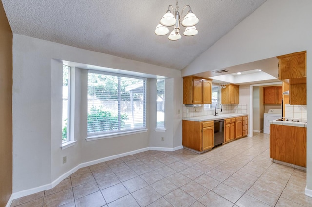 6283 N Gilroy Ave, Fresno, CA 93722 - kitchen featuring dishwasher, washer / dryer, tasteful backsplash, light tile patterned floors, and a textured ceiling