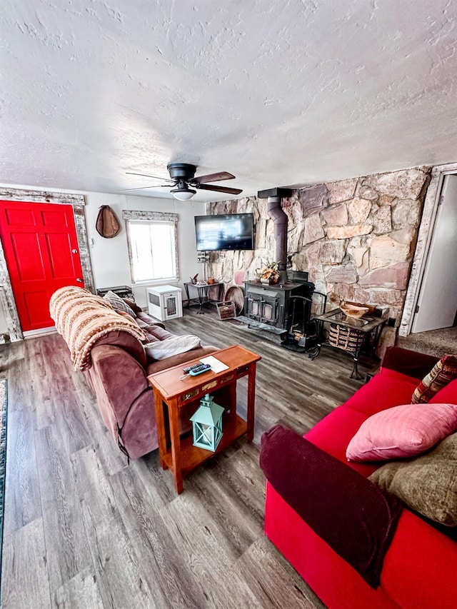 37969 Rd 422, Oakhurst, CA 93644 - living area featuring a wood stove, a textured ceiling, wood finished floors, and ceiling fan