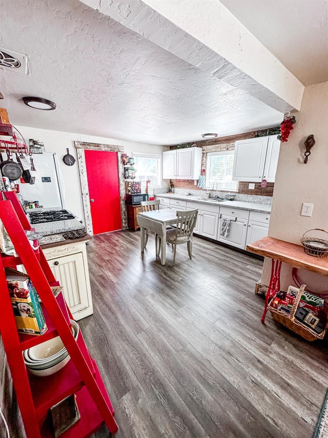37969 Rd 422, Oakhurst, CA 93644 - kitchen with light countertops, white cabinetry, dark wood-style flooring, white refrigerator, and a textured ceiling