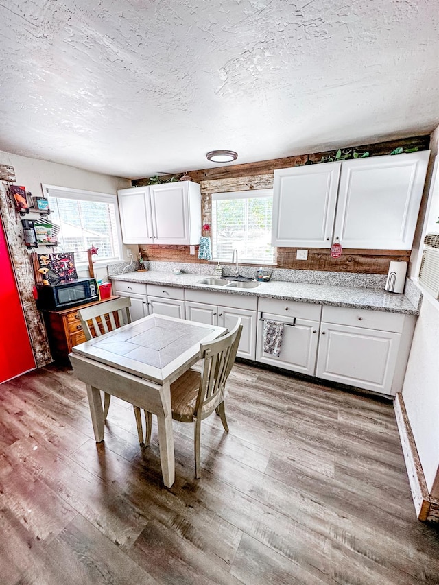 37969 Rd 422, Oakhurst, CA 93644 - kitchen featuring light wood-style floors, white cabinets, healthy amount of natural light, and a textured ceiling