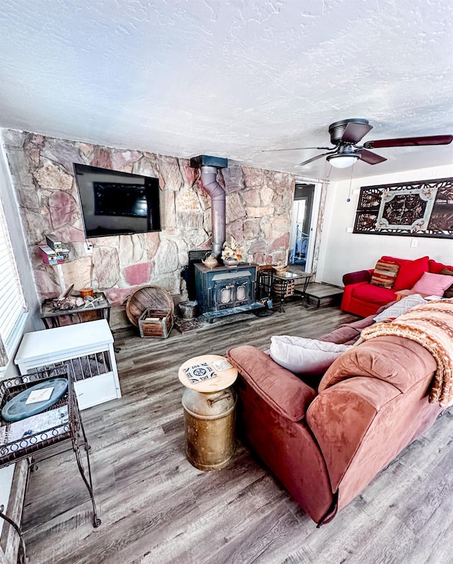 37969 Rd 422, Oakhurst, CA 93644 - living area with a wood stove, wood finished floors, a textured ceiling, and a ceiling fan