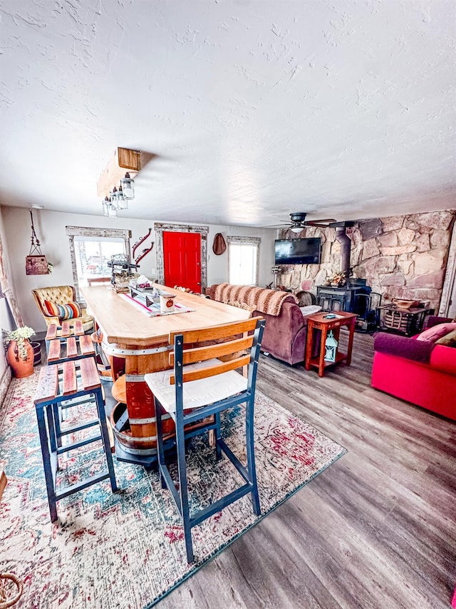 37969 Rd 422, Oakhurst, CA 93644 - dining space with a wood stove, wood finished floors, a textured ceiling, and ceiling fan
