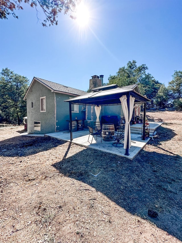 37969 Rd 422, Oakhurst, CA 93644 - back of house featuring a gazebo, stucco siding, a patio, and a chimney