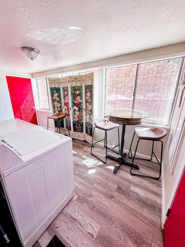 37969 Rd 422, Oakhurst, CA 93644 - bedroom featuring a textured ceiling, washer / clothes dryer, light wood-style flooring, and multiple windows