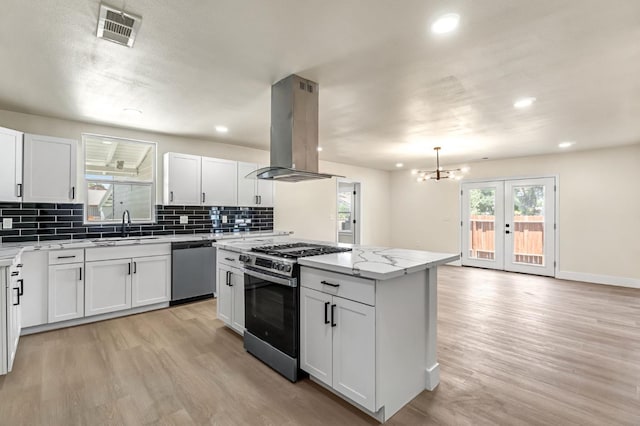 2643 B St, Selma, CA 93662 - kitchen featuring stainless steel appliances, island range hood, light wood-type flooring, backsplash, and recessed lighting
