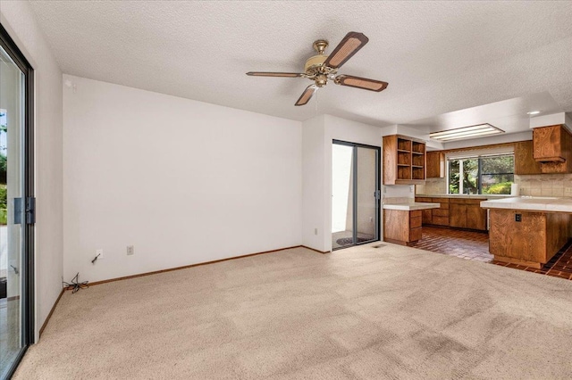 835 E Ashcroft Ave, Fresno, CA 93704 - kitchen with brown cabinets, light countertops, light colored carpet, open shelves, and a textured ceiling