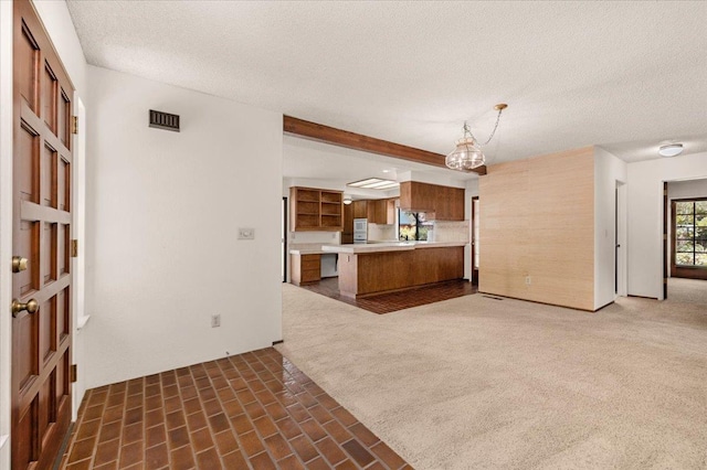 835 E Ashcroft Ave, Fresno, CA 93704 - kitchen with brown cabinetry, light countertops, a peninsula, a textured ceiling, and open floor plan