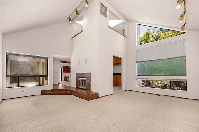 835 E Ashcroft Ave, Fresno, CA 93704 - unfurnished living room featuring track lighting, carpet floors, high vaulted ceiling, and a brick fireplace