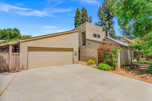 835 E Ashcroft Ave, Fresno, CA 93704 - view of front of house featuring driveway, an attached garage, and stucco siding