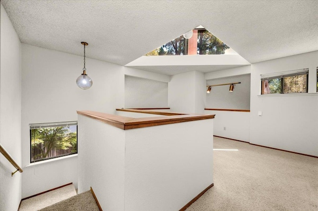 835 E Ashcroft Ave, Fresno, CA 93704 - bar with healthy amount of natural light, light carpet, vaulted ceiling, decorative light fixtures, and a textured ceiling