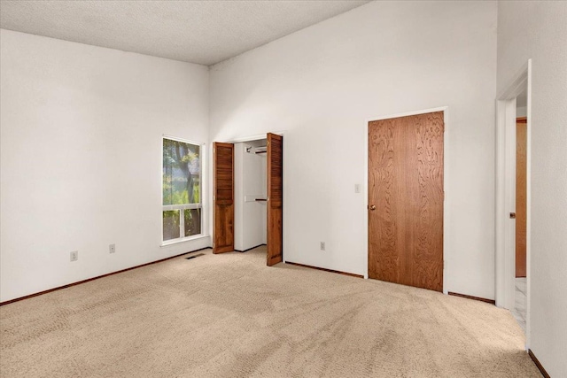 835 E Ashcroft Ave, Fresno, CA 93704 - unfurnished bedroom with carpet, a high ceiling, multiple closets, and a textured ceiling