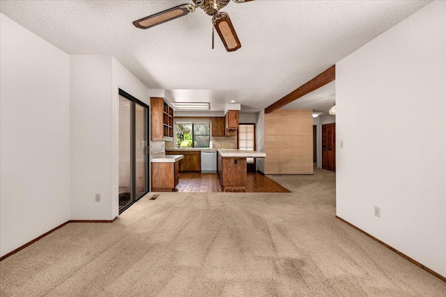 835 E Ashcroft Ave, Fresno, CA 93704 - kitchen featuring white dishwasher, brown cabinets, light countertops, light colored carpet, and a textured ceiling