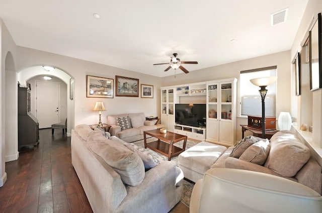 11319 N Via Napoli Dr, Fresno, CA 93730 - living room with arched walkways, ceiling fan, and dark wood-style flooring