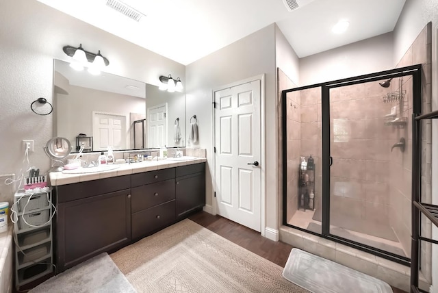 11319 N Via Napoli Dr, Fresno, CA 93730 - full bathroom with double vanity, a stall shower, and wood finished floors
