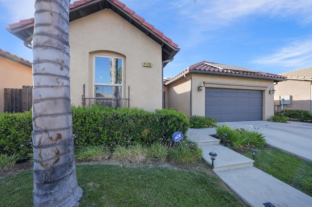 11319 N Via Napoli Dr, Fresno, CA 93730 - mediterranean / spanish-style house with a tiled roof, roof mounted solar panels, stucco siding, an attached garage, and concrete driveway