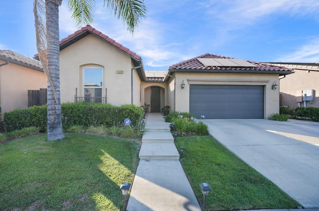 11319 N Via Napoli Dr, Fresno, CA 93730 - mediterranean / spanish-style home featuring stucco siding, driveway, a front yard, an attached garage, and roof mounted solar panels