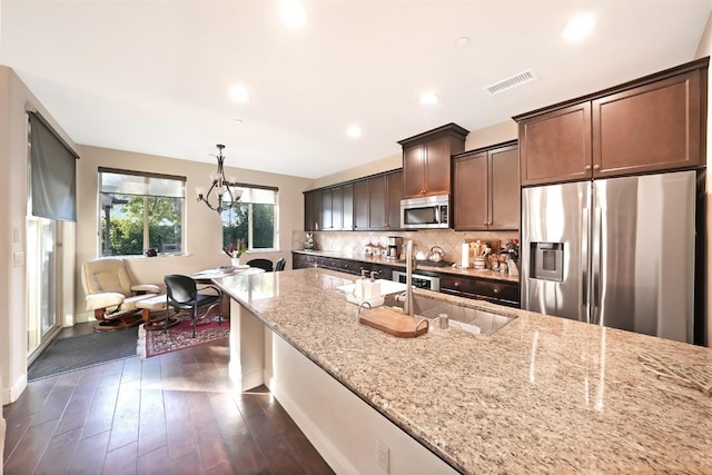 11319 N Via Napoli Dr, Fresno, CA 93730 - kitchen featuring stainless steel appliances, light stone countertops, dark wood-type flooring, tasteful backsplash, and a chandelier