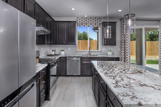 4553 Griffith Ave, Clovis, CA 93619 - kitchen featuring stainless steel appliances, plenty of natural light, under cabinet range hood, light stone counters, and recessed lighting