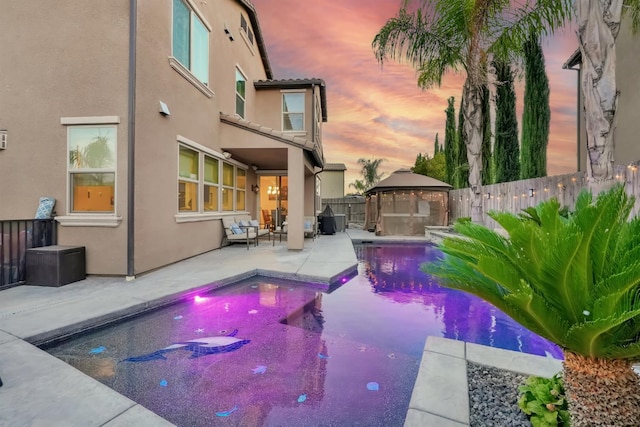 11617 N Bella Verde Ave, Fresno, CA 93730 - pool at dusk featuring a gazebo, a fenced backyard, and a patio