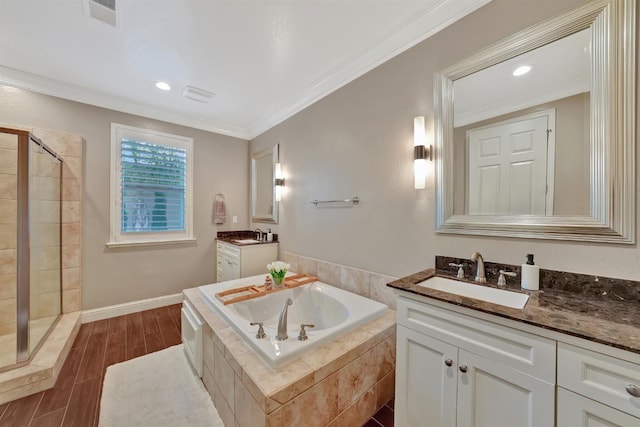 11617 N Bella Verde Ave, Fresno, CA 93730 - full bath featuring a garden tub, a stall shower, two vanities, ornamental molding, and wood finished floors