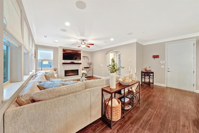 11617 N Bella Verde Ave, Fresno, CA 93730 - living area with ornamental molding, ceiling fan, dark wood-type flooring, a glass covered fireplace, and recessed lighting