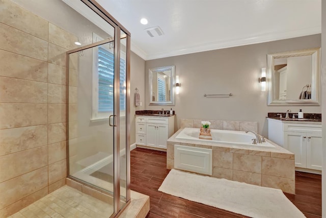 11617 N Bella Verde Ave, Fresno, CA 93730 - full bathroom featuring a stall shower, ornamental molding, two vanities, a garden tub, and wood finished floors