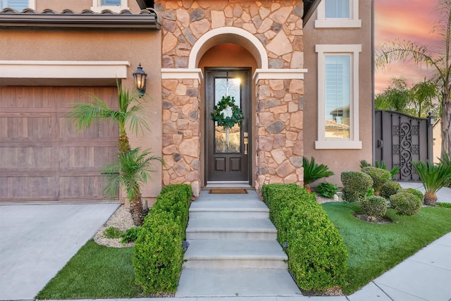 11617 N Bella Verde Ave, Fresno, CA 93730 - doorway to property featuring stone siding, stucco siding, an attached garage, and concrete driveway